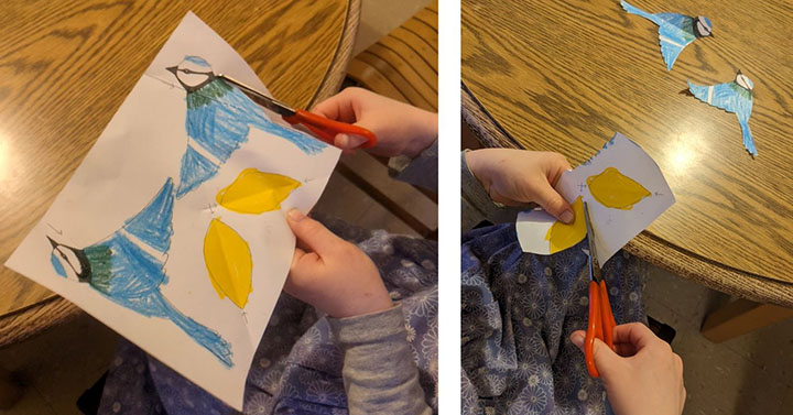 A child cutting out a coloured paper bird
