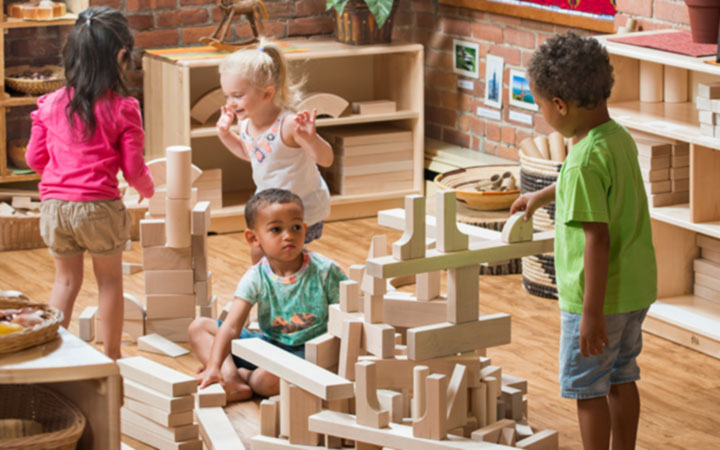 Four children building with unit blocks