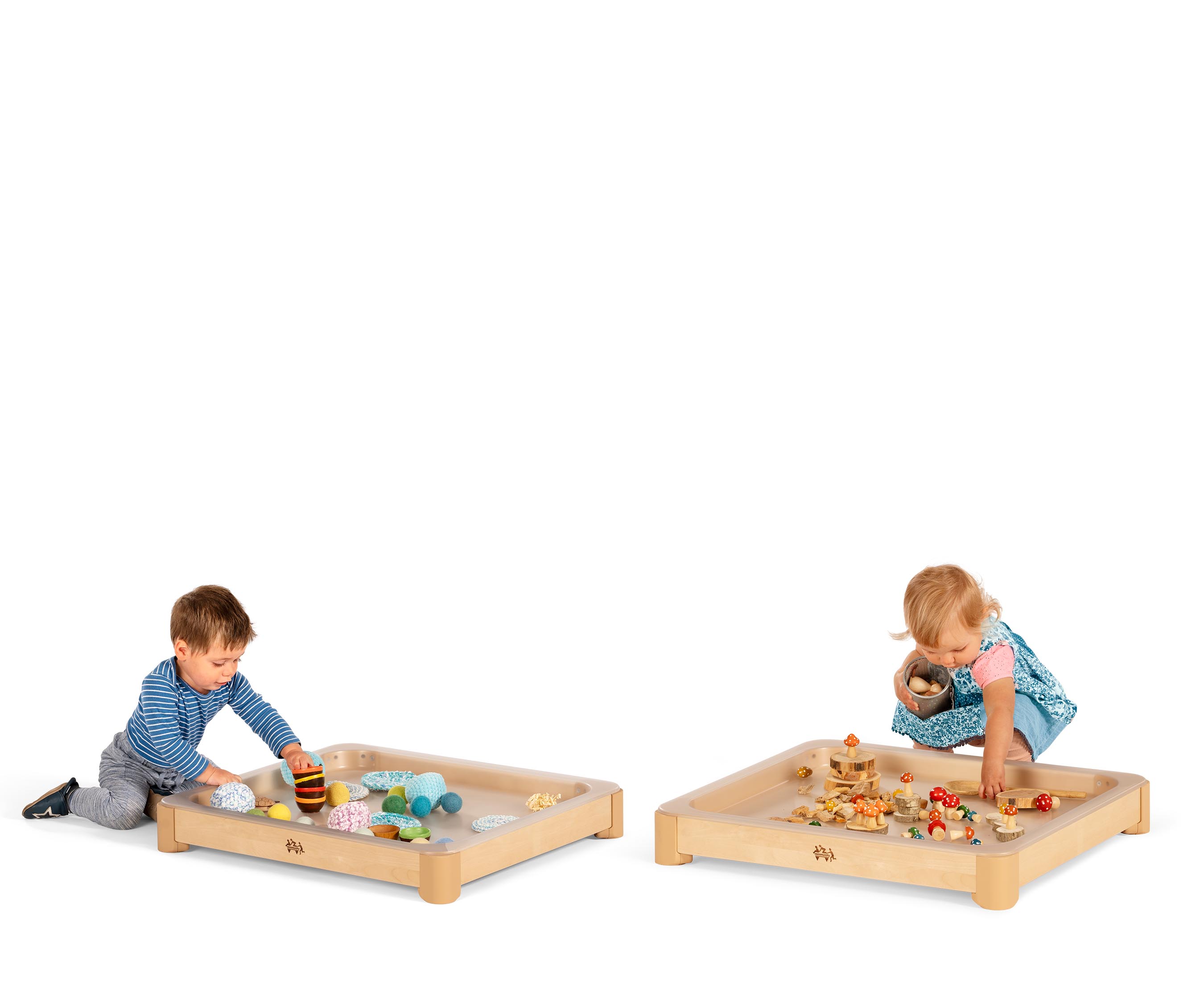 Two babies playing with loose parts and natural materials in the Activity floor tray, an alternative to the tuff tray with a natural look.