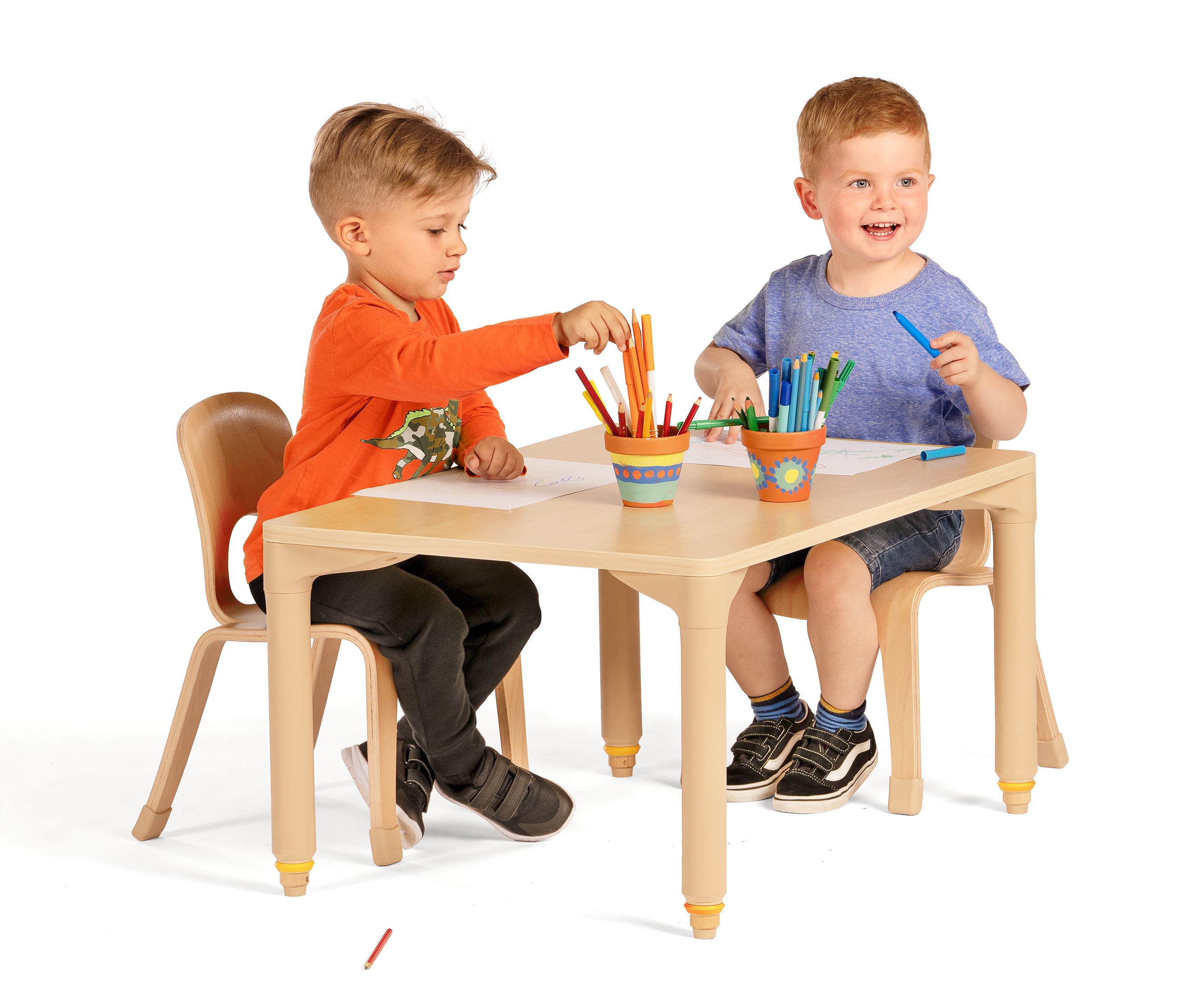 Two boys sitting in Woodcrest chairs doing mark-making at table