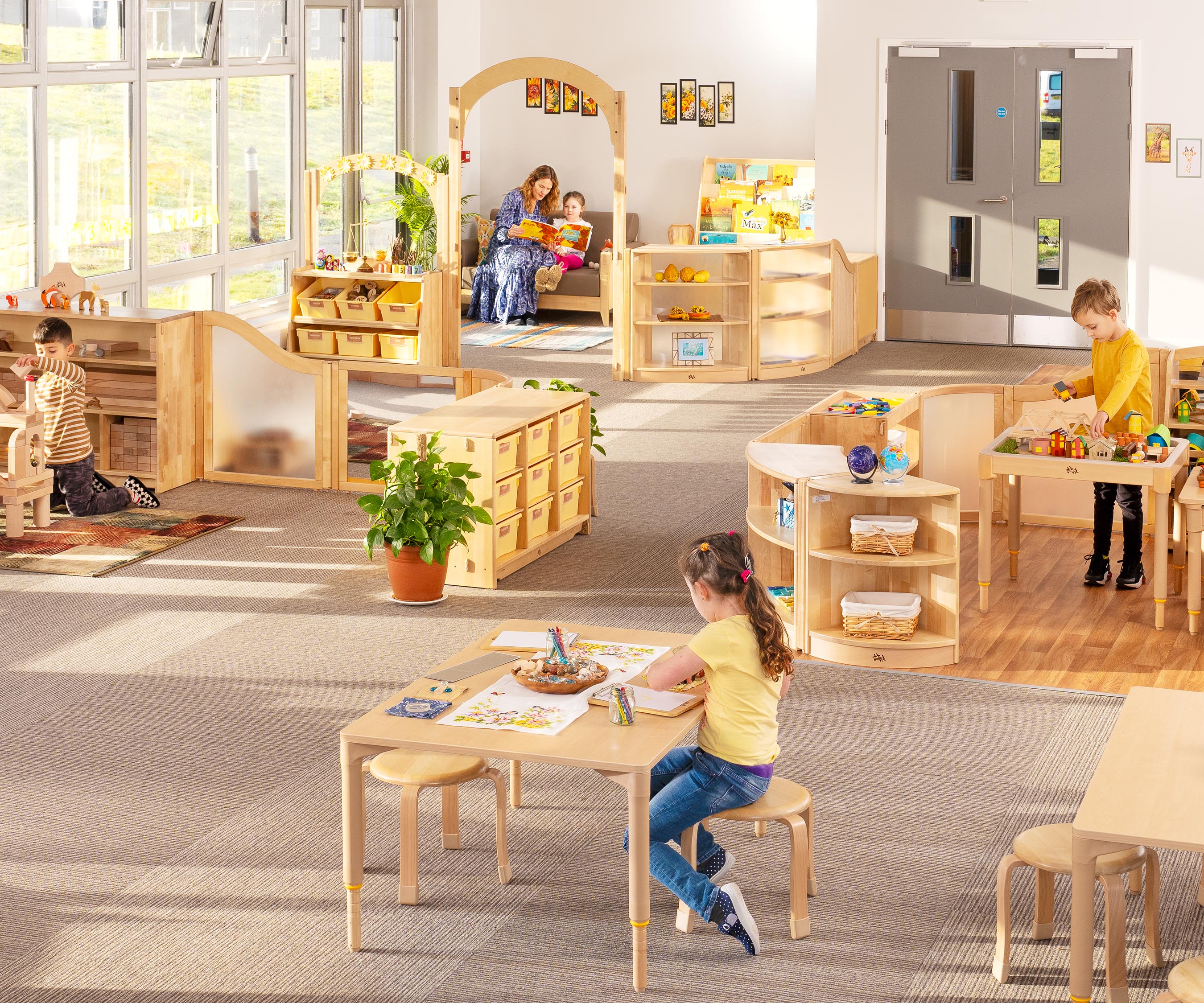 A reception or kindergarten classroom set up with natural wood furniture to create the EYFS areas