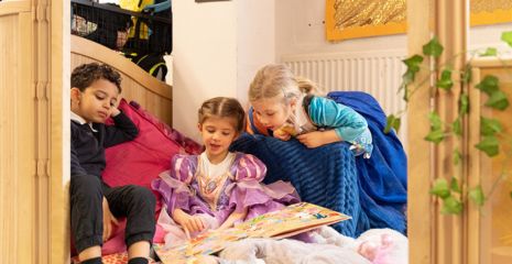 3 children reading a book in a calm corner