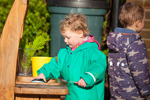 two young children playing at the Outlast mud kitchen