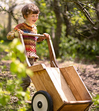 A boy tipping an Outlast wheelbarrow